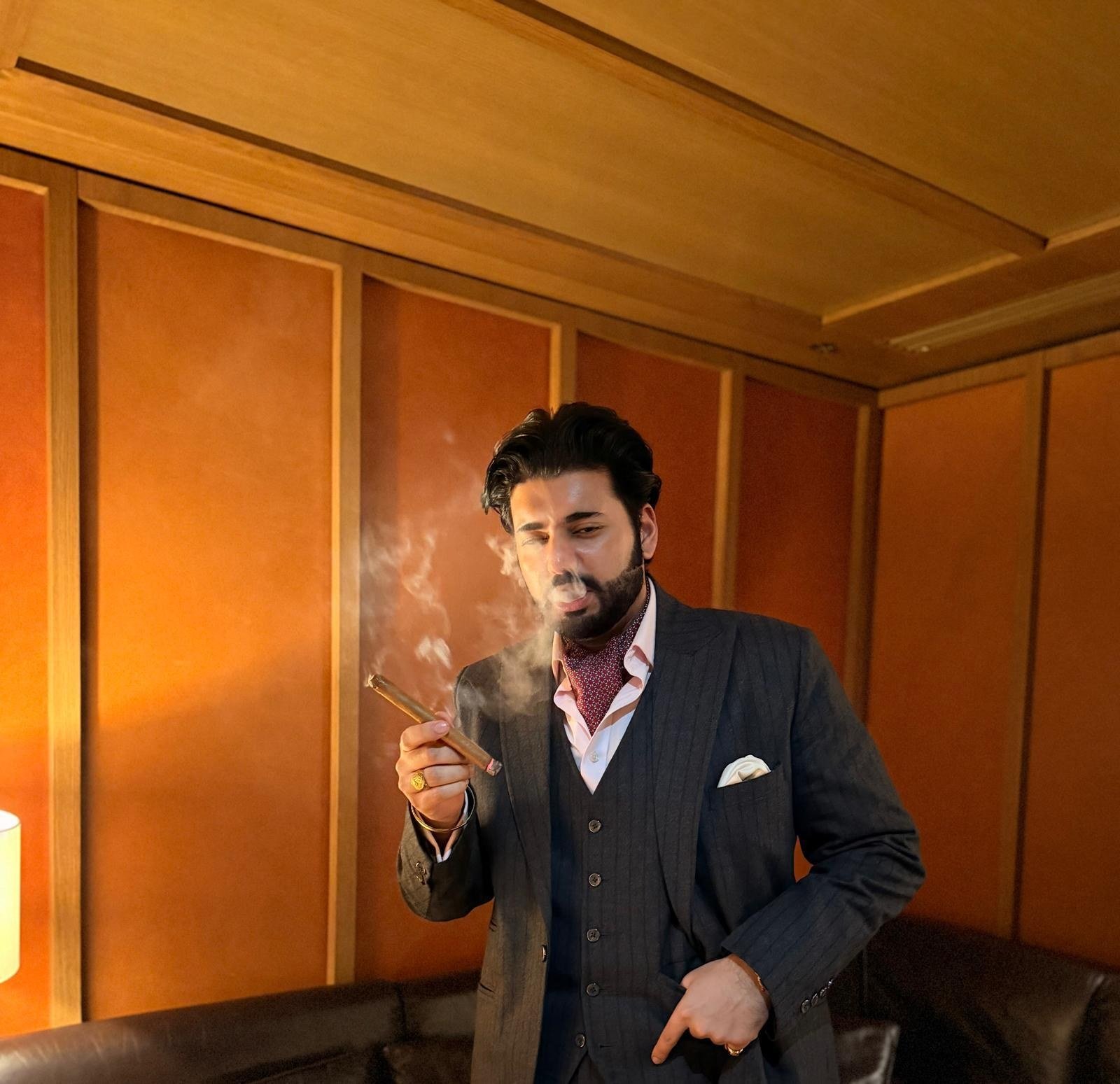 Manvedeep Singh with a cigar in a panelled room